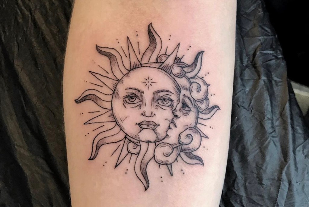 Tatuointi, jossa aurinko ja kuu esitetään kasvoina lomittain. Kuva liittyy artikkeliin, jossa kerrotaan auringon vaikutuksista tatuoinnin kestävyyteen ja väreihin.
