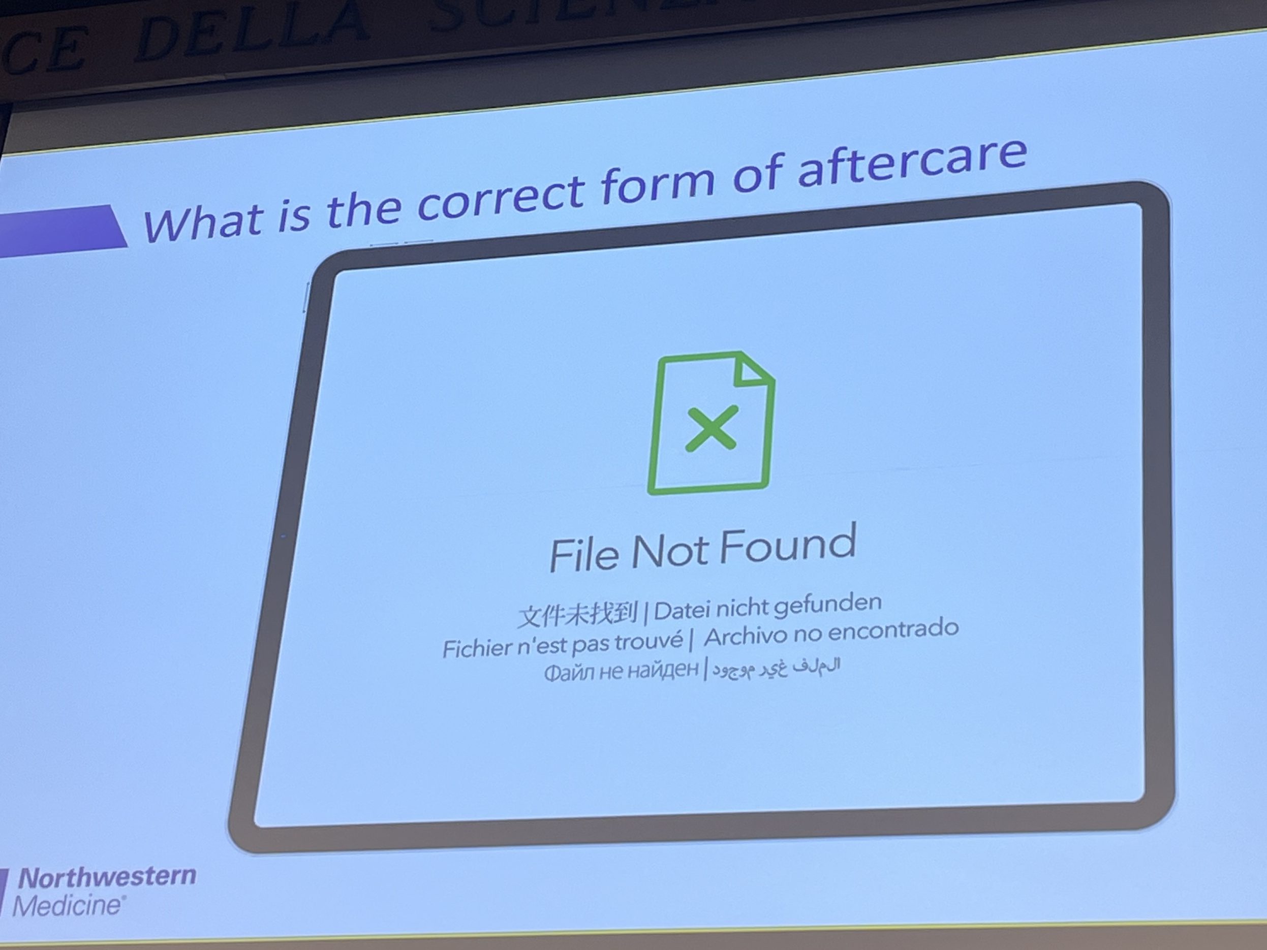 Esitysdia, jonka otsikkona on ‘What is the correct form of aftercare’. Näytöllä näkyy virheilmoitus ‘File Not Found’, humoristisena viittauksena siihen, ettei tatuoinnin jälkihoidosta ole yksimielisyyttä.